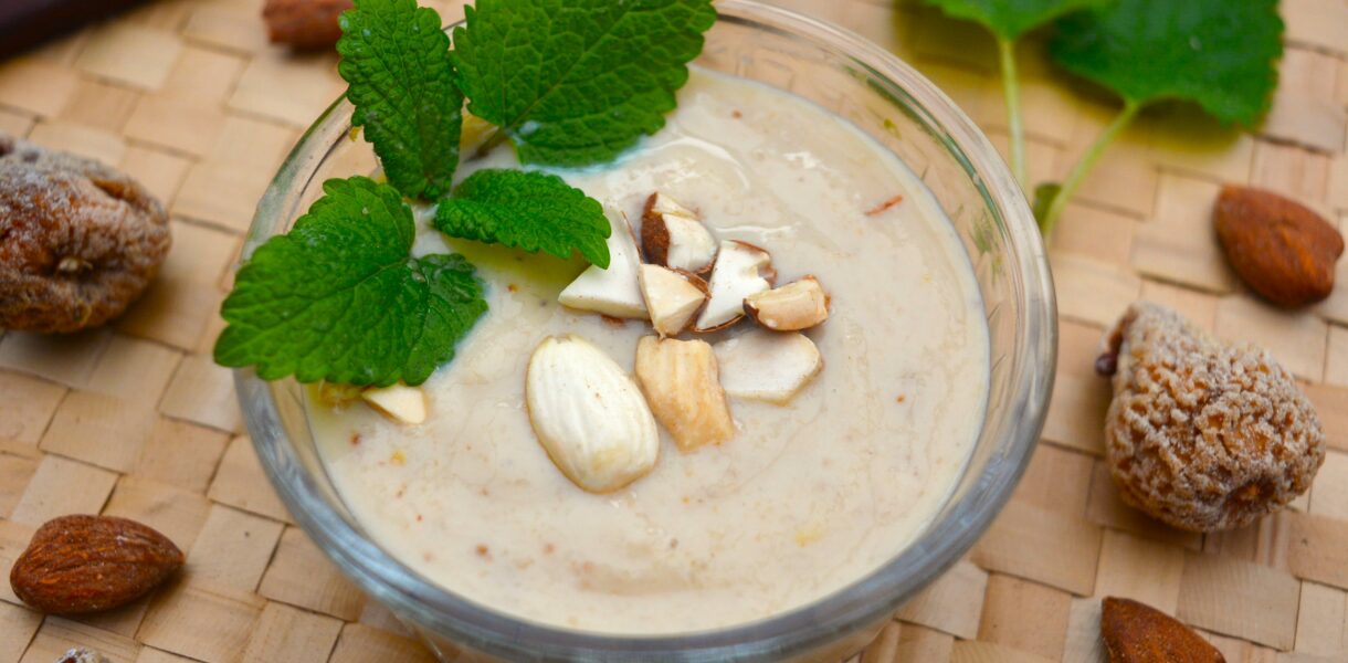 Crème onctueuse à la figue avec amandes grillées concassées et feuilles de mélisse en décoration